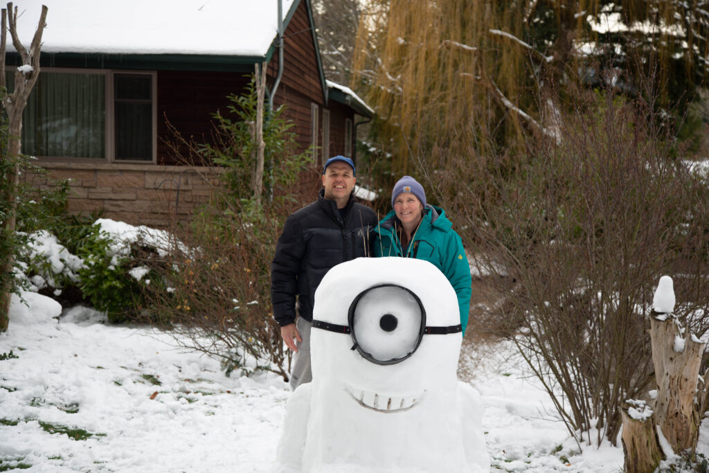 The author and her husband, creators of Stuart the one-eyed minion from Despicable Me. The snow was not perfect -- it took multiple attempts to get a ball to roll -- but we pounced on the several-hour window of "good enough" warming to make this cute critter. He's not perfect - he's white, not yellow, and his bamboo hair sticks straight up instead of a comb-over, but "he's good enough."