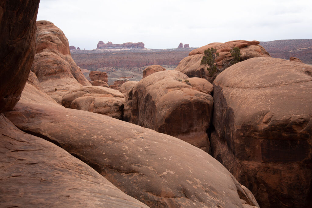 Slickrock sandstone showing rounding from erosion. Rangers close the maze if there is any snowfall as the moisture makes footing treacherous and hides the washes and rocks where visitors must step.