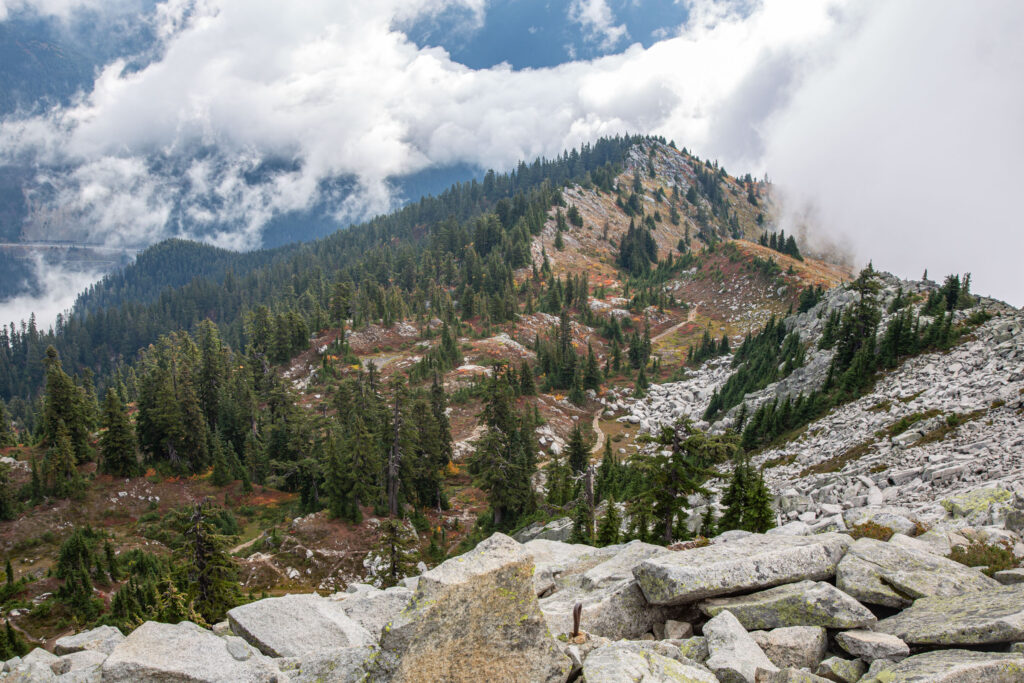 View looking east from the Lookout Tower on Granite Mountain. The summer "main trail" weaves through the basin in the center of the photo and eastbound I-90 can be seen behind the mountain far left.