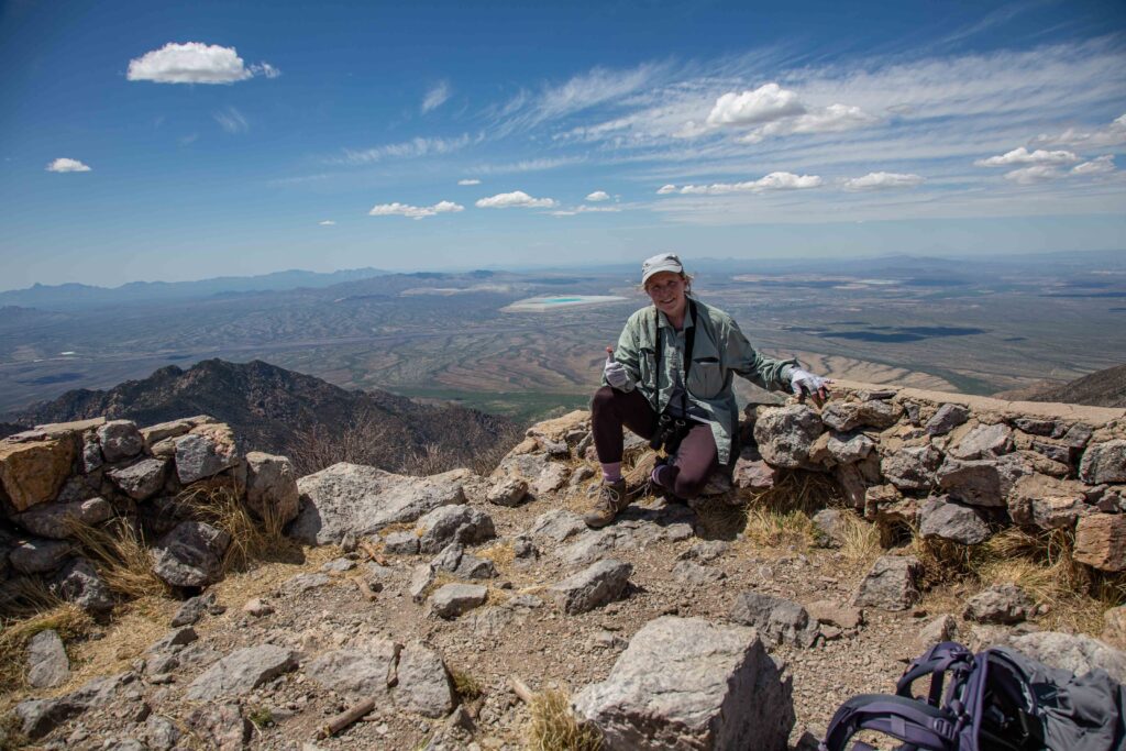 I crouch on the summit of Mt. Wrightson in SE AZ, 9500' high, with stunning views of sky islands in all directions.