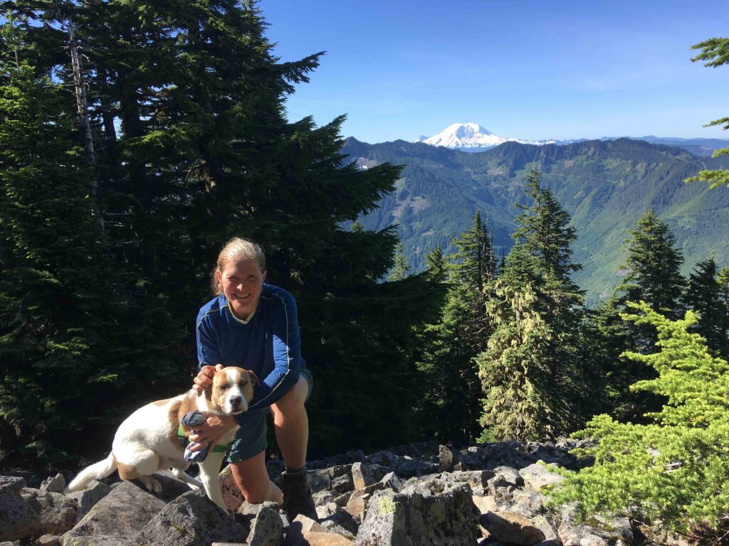 Coach Court and Ajax on Dirty Harry's Peak with Mt. Rainier in the background.