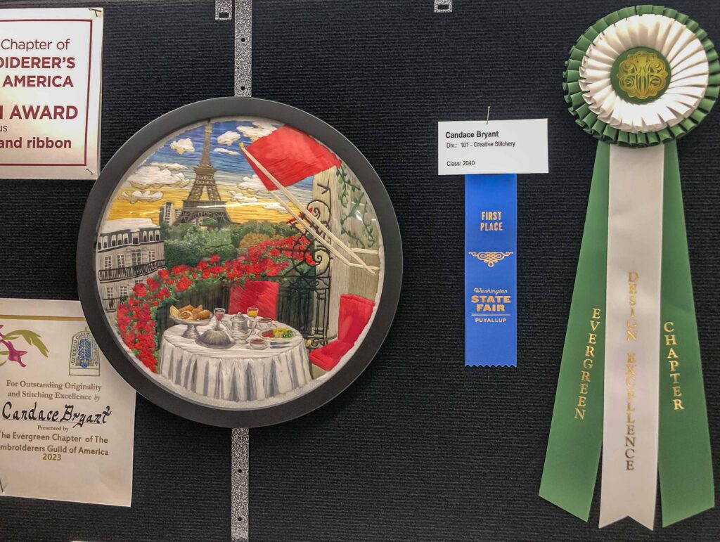 The embroidery piece that won the blue ribbon at the Washington State Fair is an intricate Parisian cafe scene.