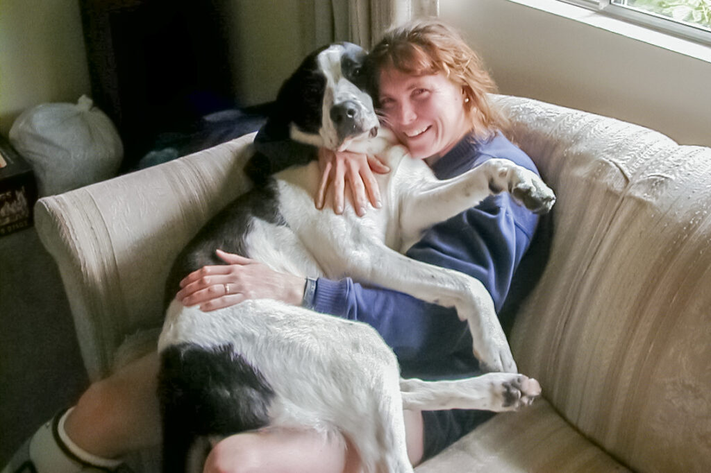 The author in my younger days, sporting a casted right leg and holding our previous dog, Emily.