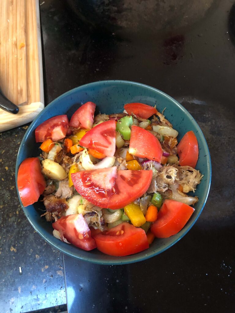 A homemade protein-rich lunch of leftovers: tomato, pulled pork, raw veggies (peppers, celery, carrots, water chestnuts), and roasted potatoes cooked in avocado oil and sea salt. Delicious.