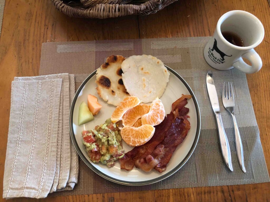 A sample breakfast: 2 slices of melon, half a Sumo orange, a healthy dollop of guacamole, 3 strips of lean bacon, and two small gluten-free rice flour tortillas. All homemade. All delicious. And decaffeinated Market Spice tea.