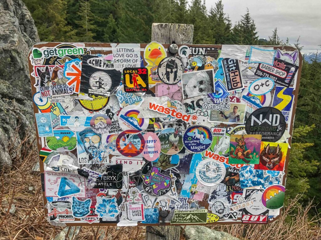 My analogy breaks down a little bit in that on a trail we usually have two choices: forward or back. In life, we have so many obstacles and challenges thrown at us that it might look a little like this sign covered in stickers. But the approach, TAKE THE NEXT STEP, still holds.
