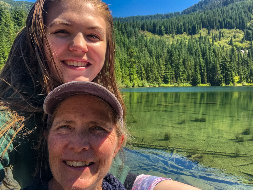 My daughter takes a selfie of us perched on a large rock in the middle of the shallowest part of the lake.