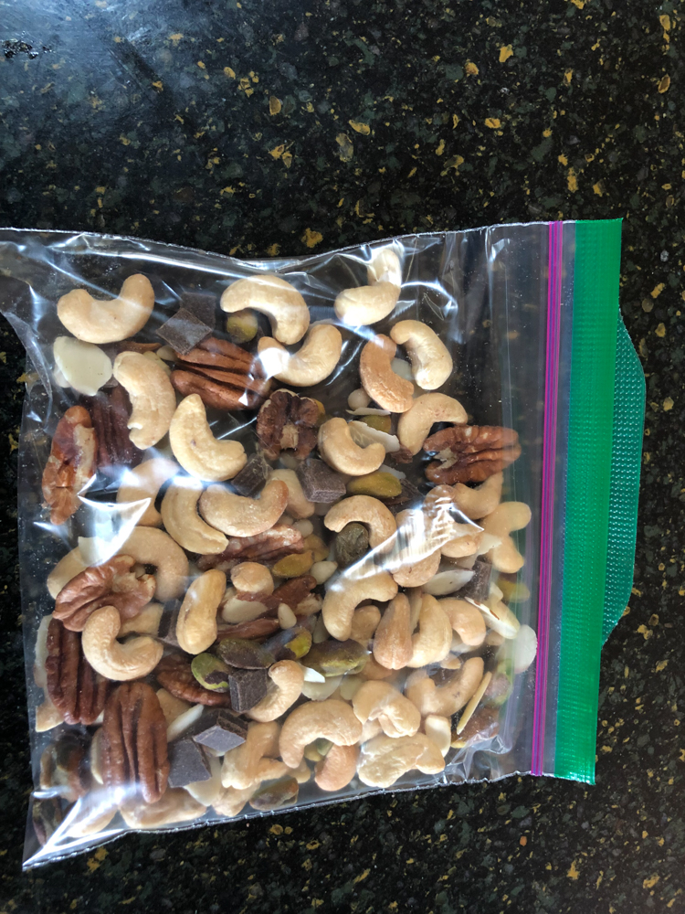 Homemade GORP consisting of cashews, pistachios, pecans, pine nuts, slivered almonds, and chocolate chunks.